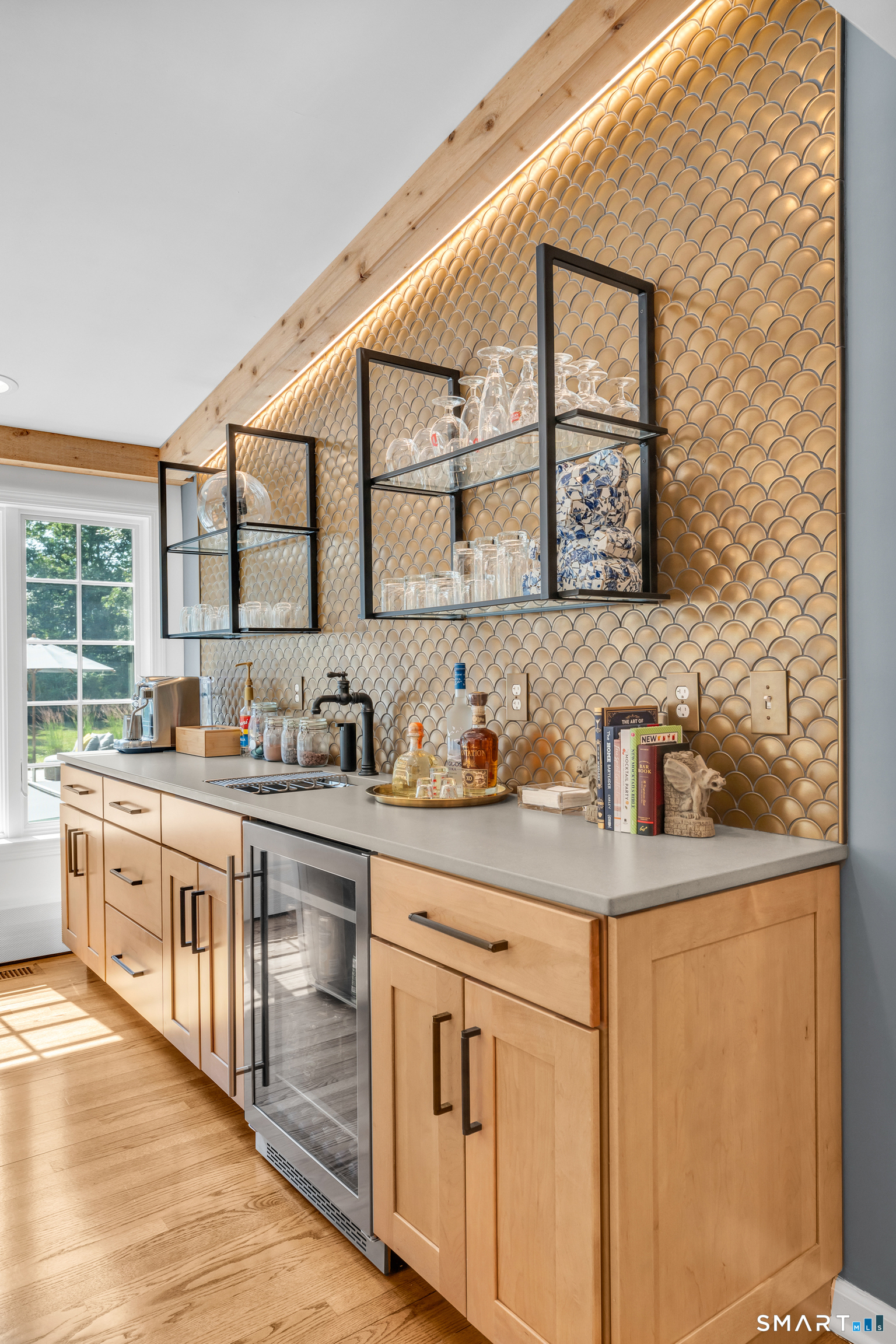 33 River Edge Farms Road Madison, CT 06443 - Photo 12 of 40 A beautifully appointed wet bar with a striking gold tile backsplash adds a touch of elegance to every gathering.