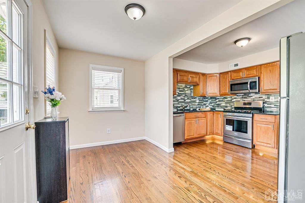 119 Wagner Street Edison, NJ 08837 - Photo 17 of 41 a kitchen with granite countertop wooden floors stainless steel appliances and window
