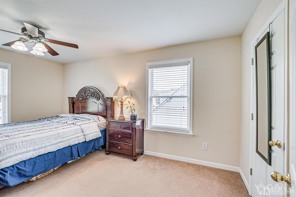 119 Wagner Street Edison, NJ 08837 - Photo 25 of 41 a bedroom with a bed next to a window and a chandelier