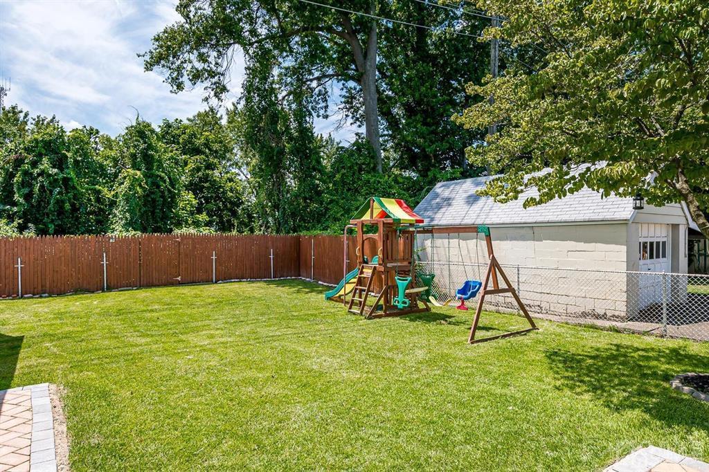 119 Wagner Street Edison, NJ 08837 - Photo 38 of 41 a view of a backyard with a slide trees and wooden fence
