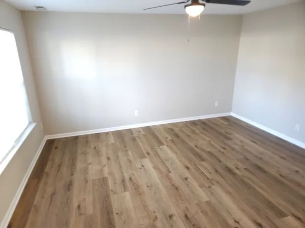 a view of an empty room with wooden floor