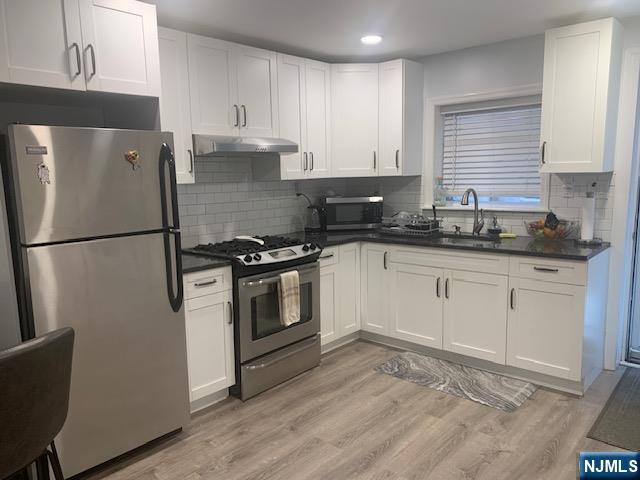 414 7th Street Fairview, NJ 07022 - Photo 2 of 6 a kitchen with granite countertop a sink stainless steel appliances and cabinets