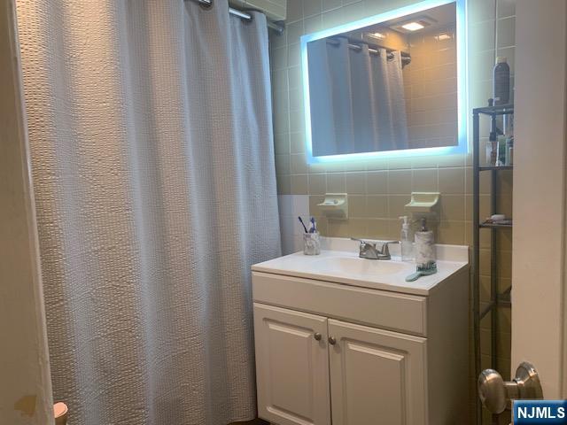414 7th Street Fairview, NJ 07022 - Photo 6 of 6 a bathroom with a sink a vanity and a mirror