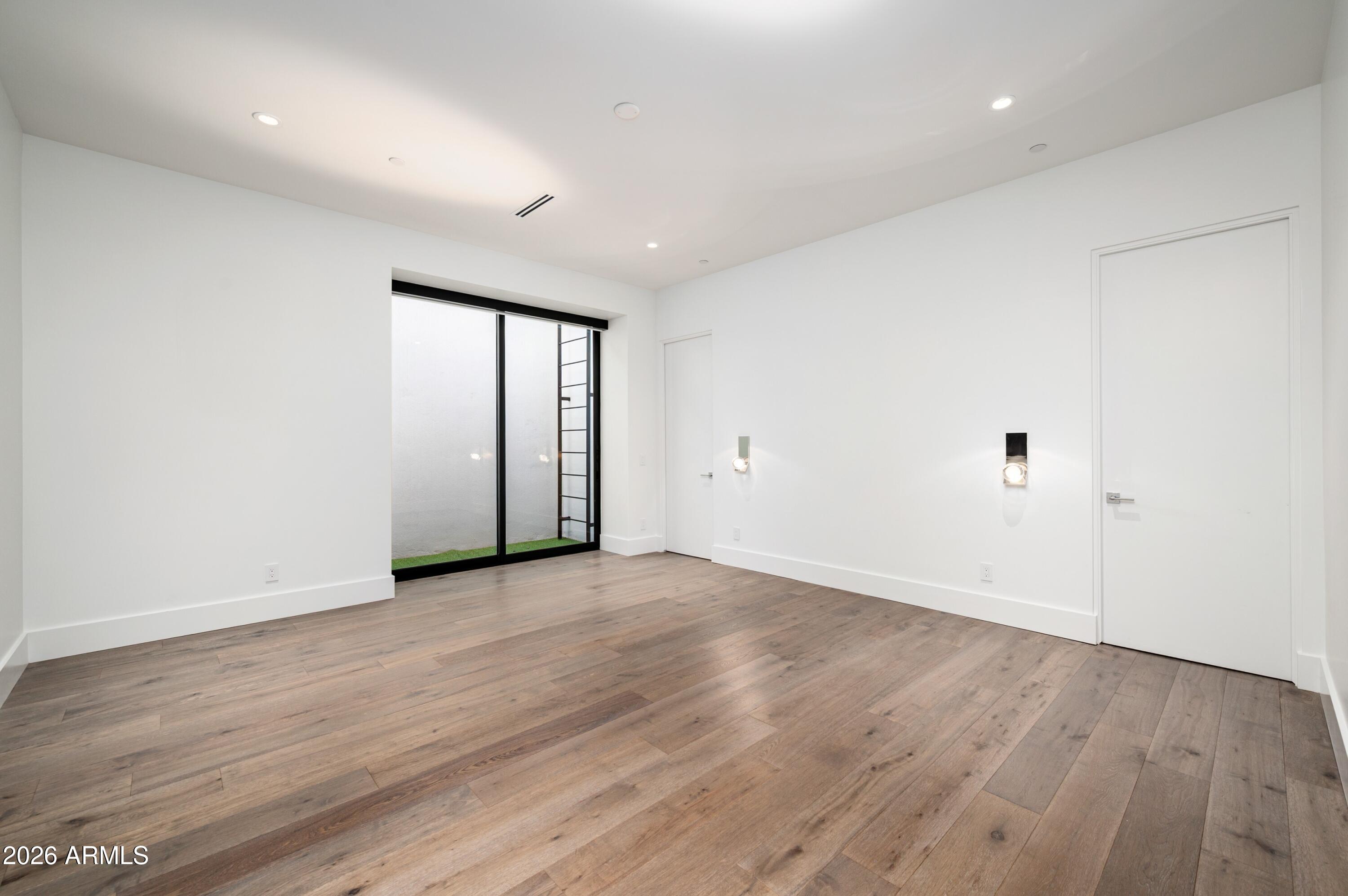 6914 East Cactus Wren Road Paradise Valley, AZ 85253 - Photo 26 of 38 an empty room with wooden floor and white walls