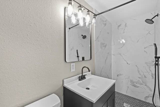a bathroom with a sink mirror and toilet