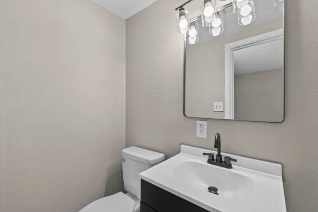 a bathroom with a sink a toilet and mirror