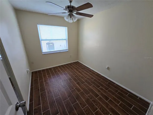 a view of a room with wooden floor and fan