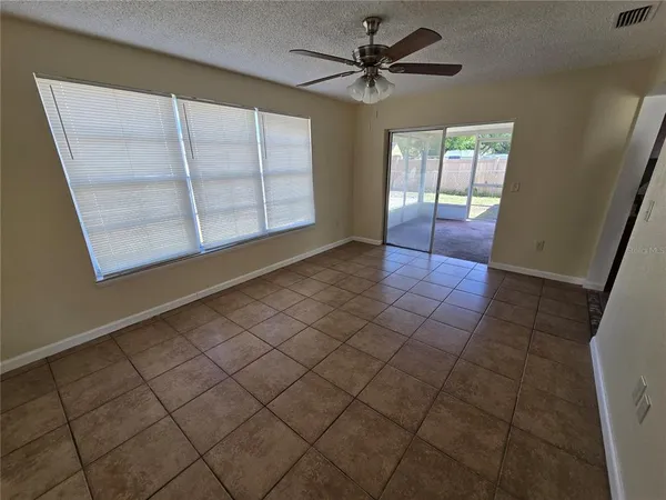 en empty room with windows and fan