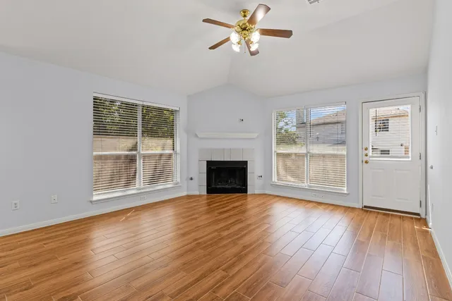 a view of empty room with wooden floor and fireplace