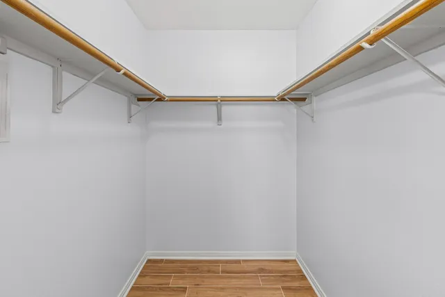 an empty room with chandelier fan and hallway