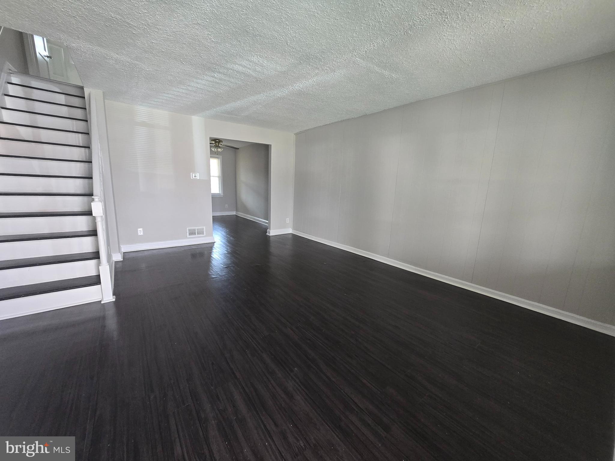 803 North Marlyn Avenue Baltimore, MD 21221 - Photo 2 of 22 a view of an empty room with wooden floor and a window