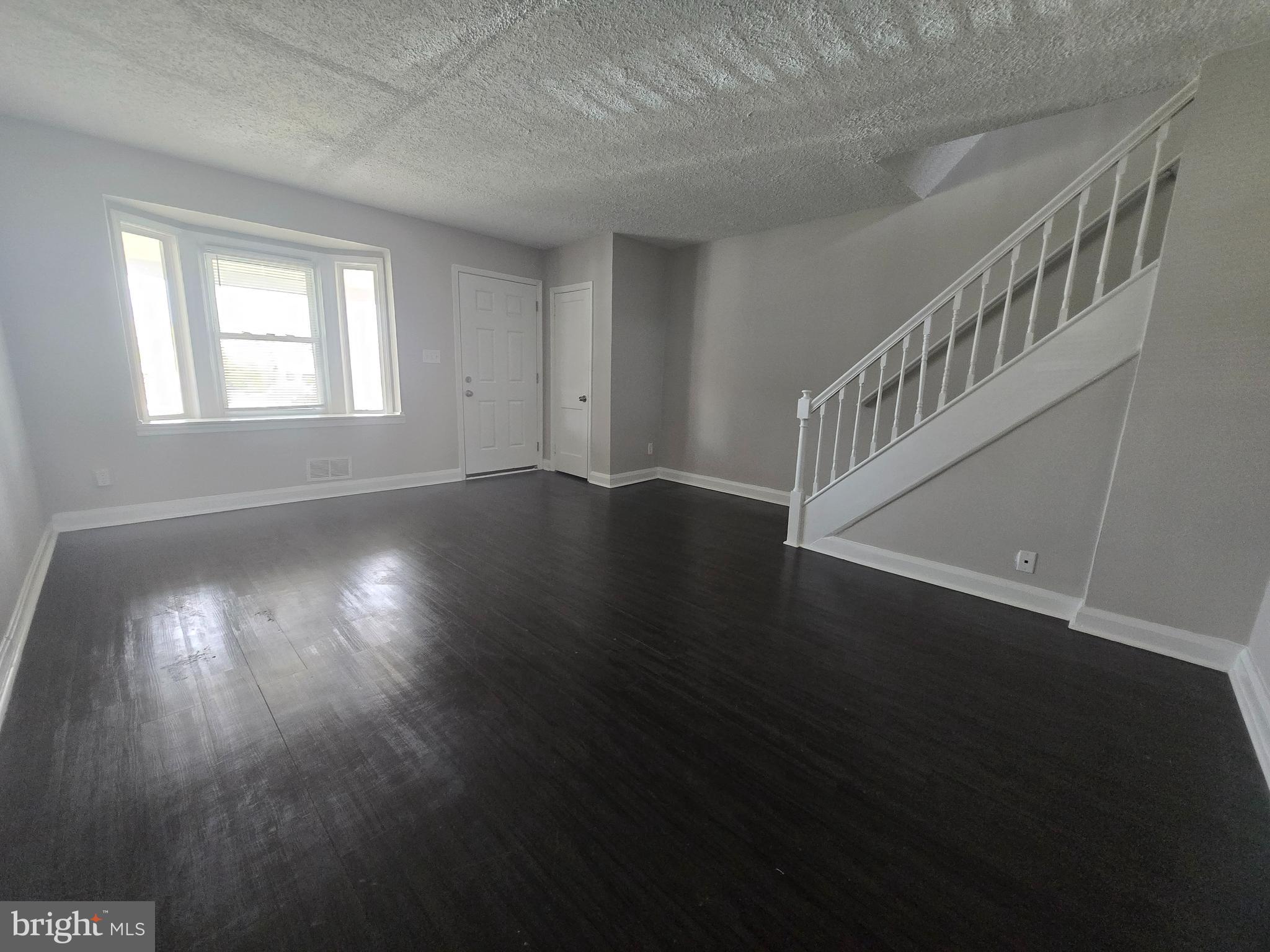 803 North Marlyn Avenue Baltimore, MD 21221 - Photo 3 of 22 a view of an empty room with wooden floor and a window