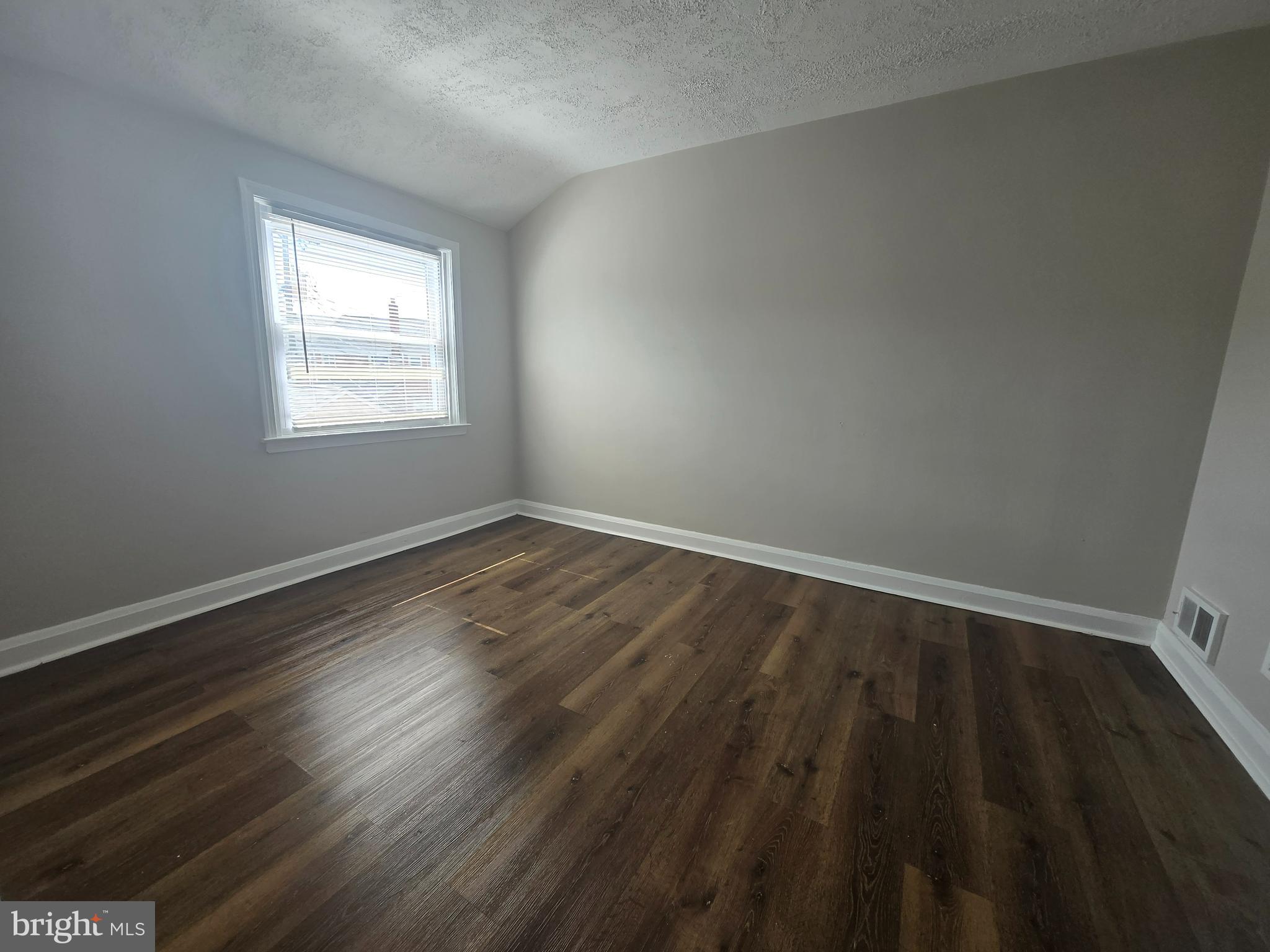 803 North Marlyn Avenue Baltimore, MD 21221 - Photo 7 of 22 a view of an empty room with wooden floor and a window