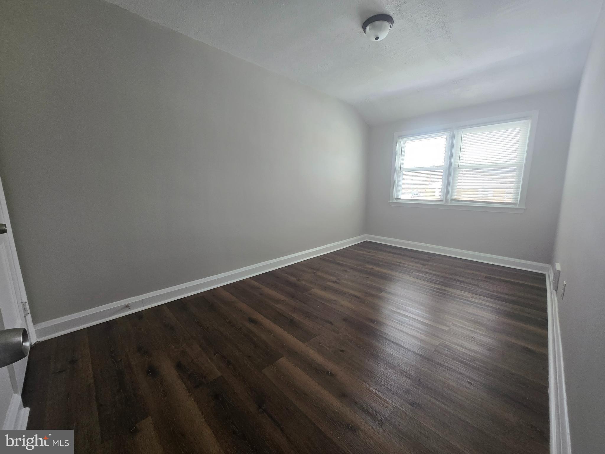 803 North Marlyn Avenue Baltimore, MD 21221 - Photo 8 of 22 an empty room with wooden floor and windows