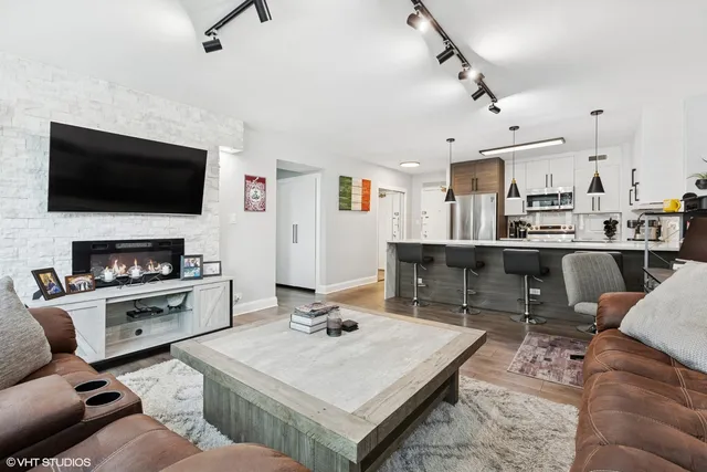 a living room with a flat screen tv and kitchen view