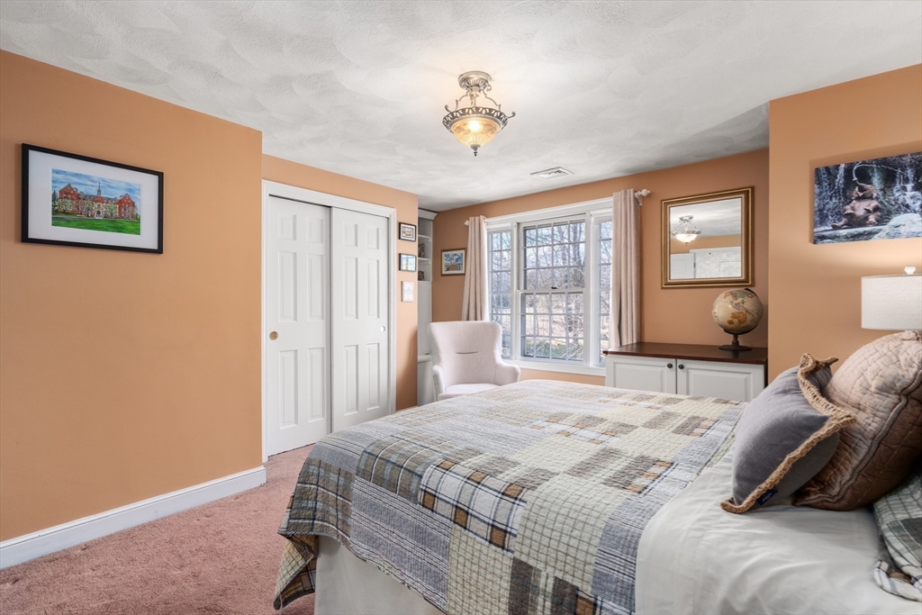 4 Greybirch Road Andover, MA 01810 - Photo 25 of 42 a bedroom with a large bed and a chandelier