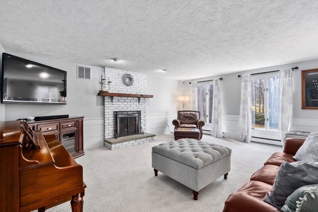 4 Greybirch Road Andover, MA 01810 - Photo 5 of 42 a living room with furniture a flat screen tv and a fireplace