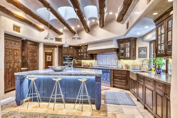 a kitchen with stainless steel appliances kitchen island granite countertop a table chairs in it and wooden floors