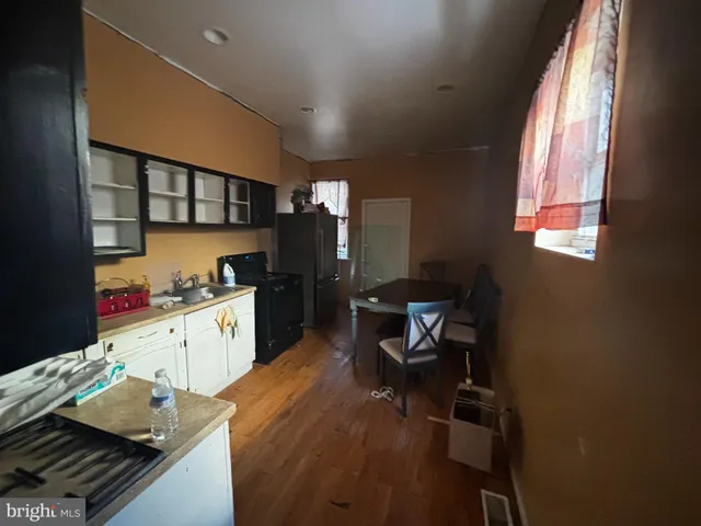 a kitchen with a sink and wooden floor