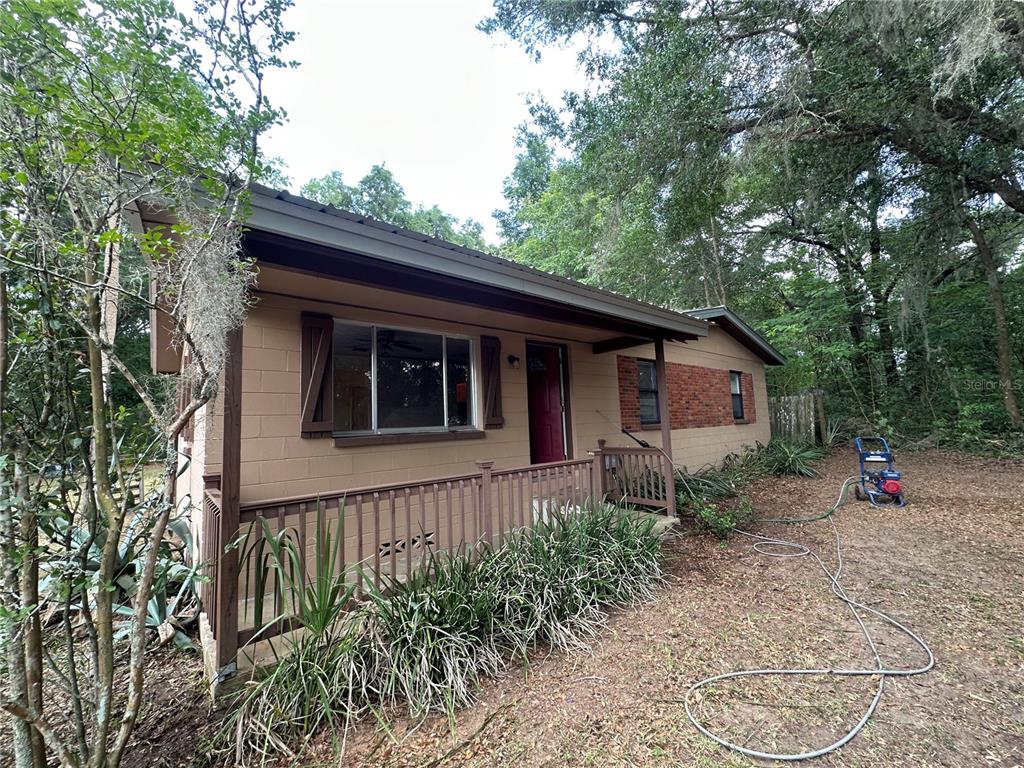 13449 Northeast Jacksonville Road Citra, FL 32113 - Photo 1 of 6 a backyard of a house with wooden fence and large trees