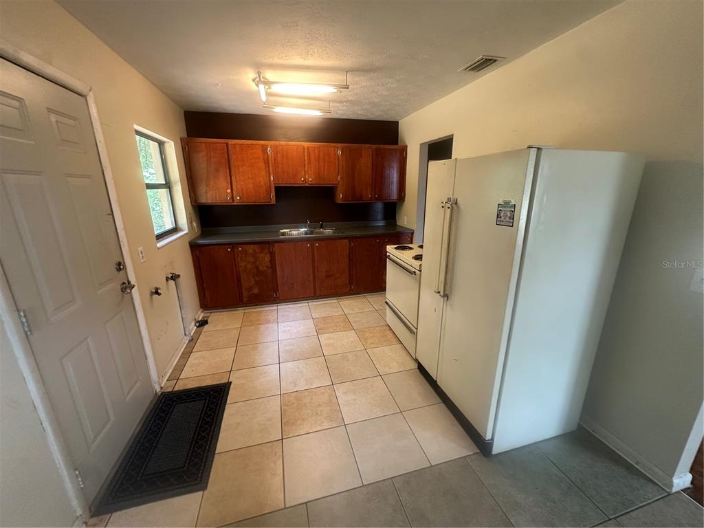 13449 Northeast Jacksonville Road Citra, FL 32113 - Photo 2 of 6 a kitchen with a refrigerator and a counter