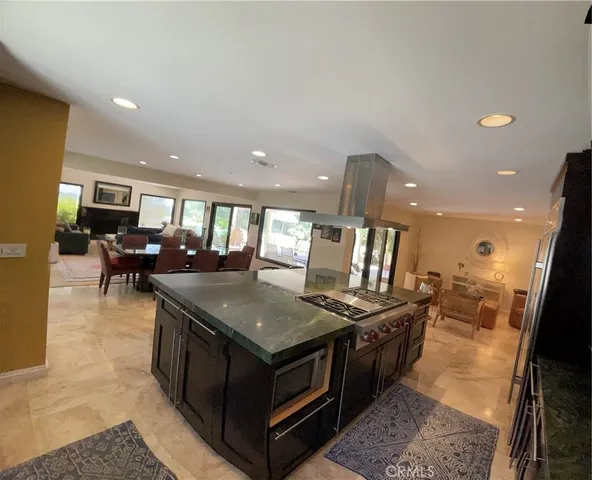 a kitchen with stainless steel appliances granite countertop a stove top oven a sink and a refrigerator