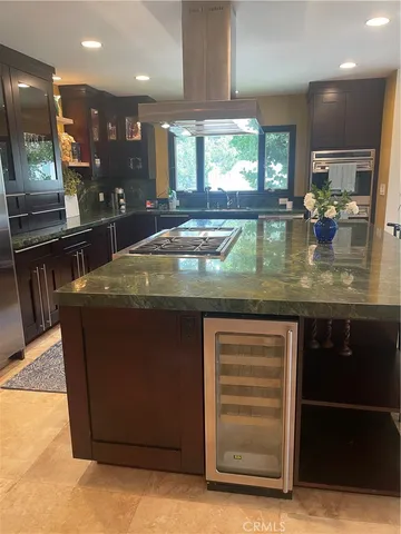 a kitchen with kitchen island granite countertop a large counter top stainless steel appliances and cabinets