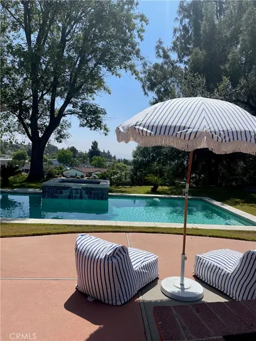 swimming pool view with a seating space