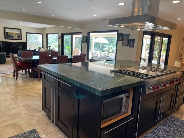 a kitchen with stainless steel appliances granite countertop a stove a sink and a refrigerator