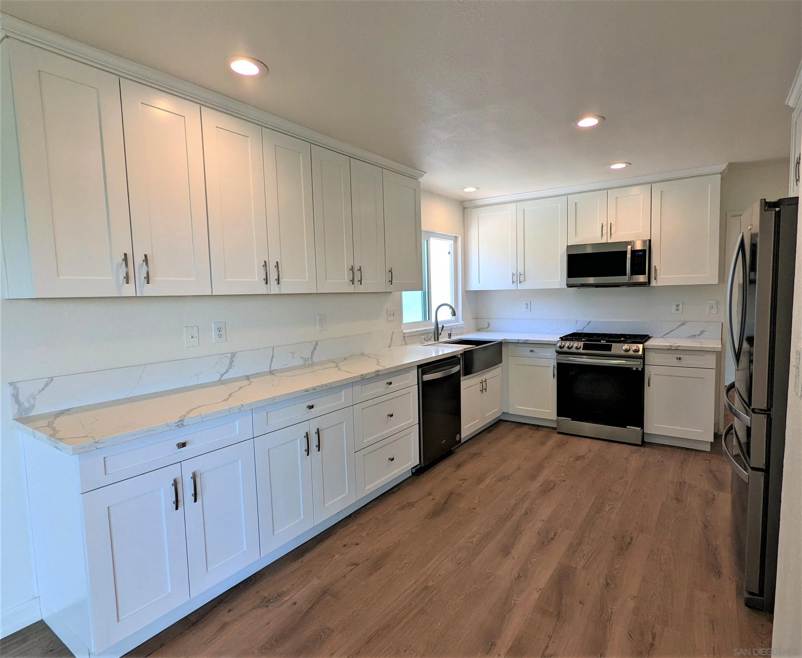 9347 Kahlua Way Spring Valley, CA 91977 - Photo 12 of 67 a kitchen with granite countertop white cabinets and stainless steel appliances