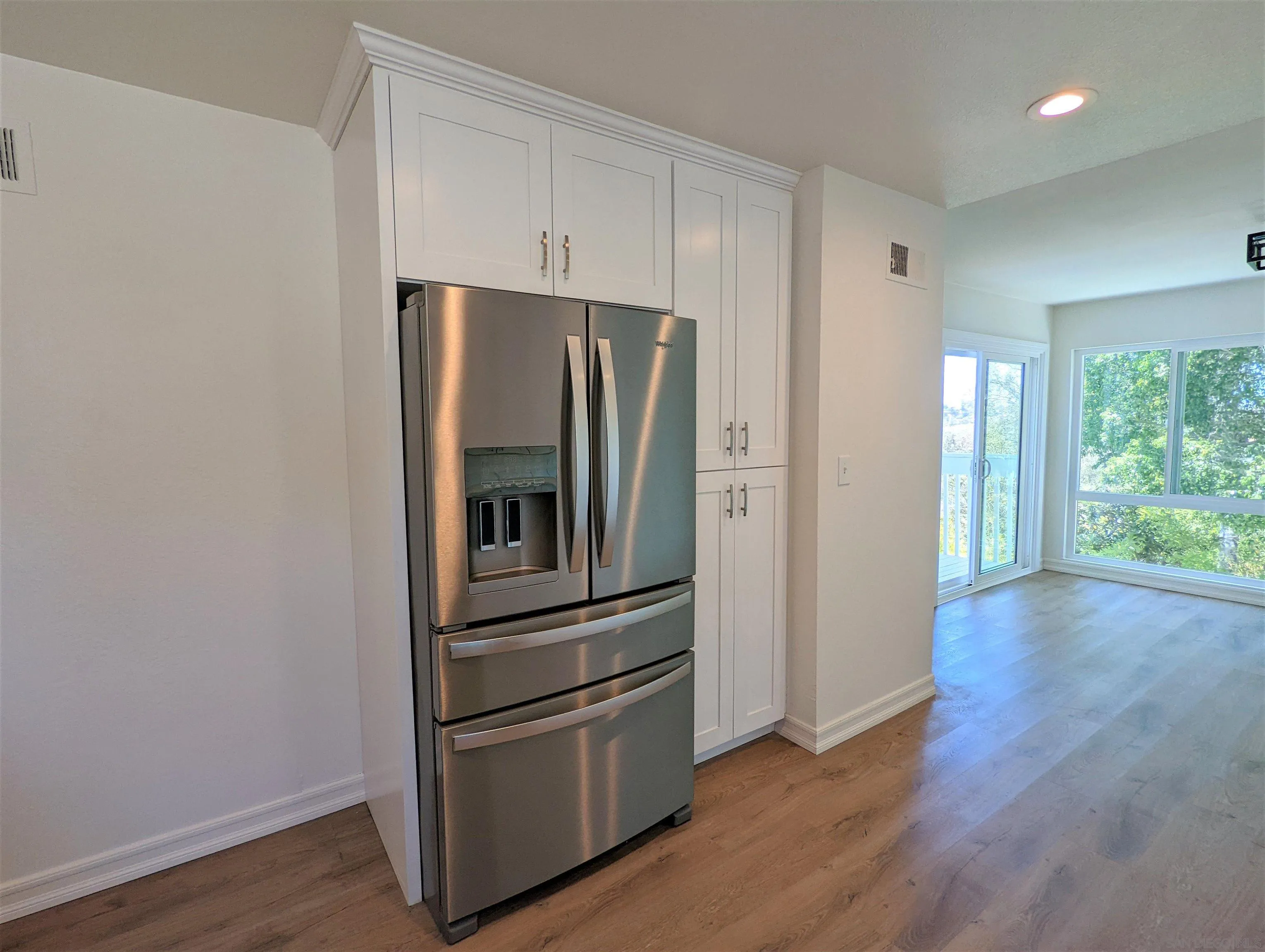 9347 Kahlua Way Spring Valley, CA 91977 - Photo 17 of 67 a kitchen with wooden floors and stainless steel appliances