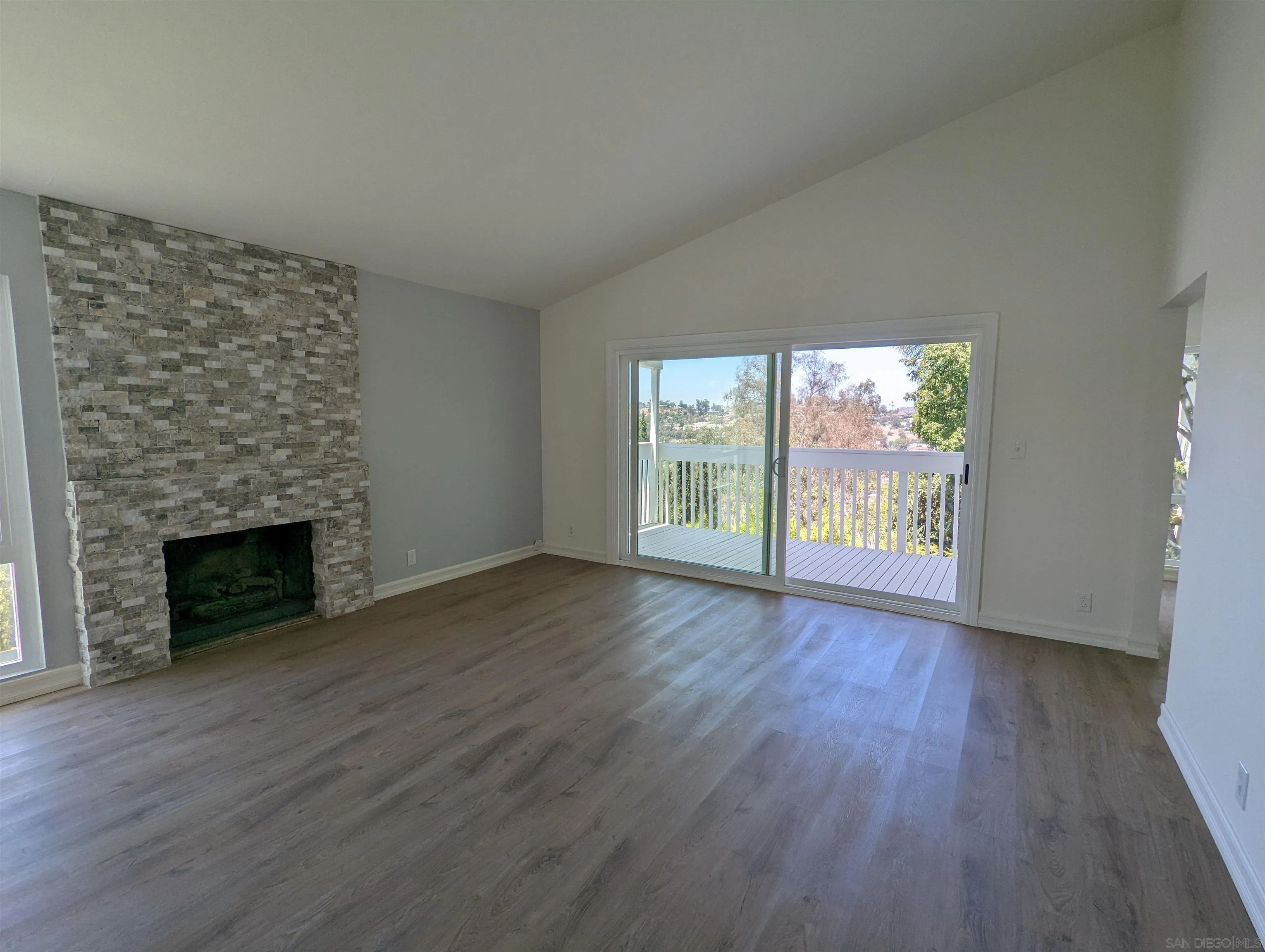 9347 Kahlua Way Spring Valley, CA 91977 - Photo 18 of 67 an empty room with wooden floor fireplace and windows
