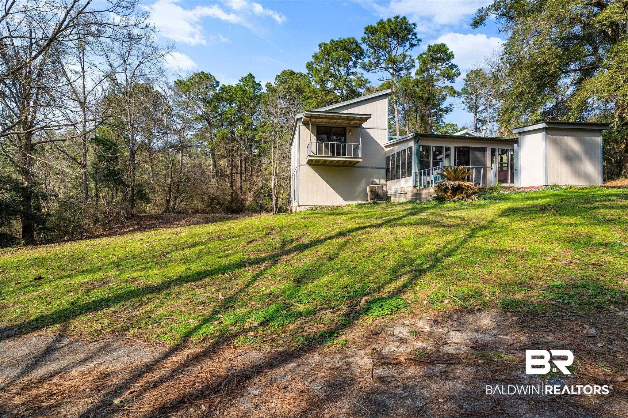 8451 Nugget Drive Mobile, AL 36695 - Photo 2 of 12 Rear view of house with a lawn, a sunroom, and a balcony