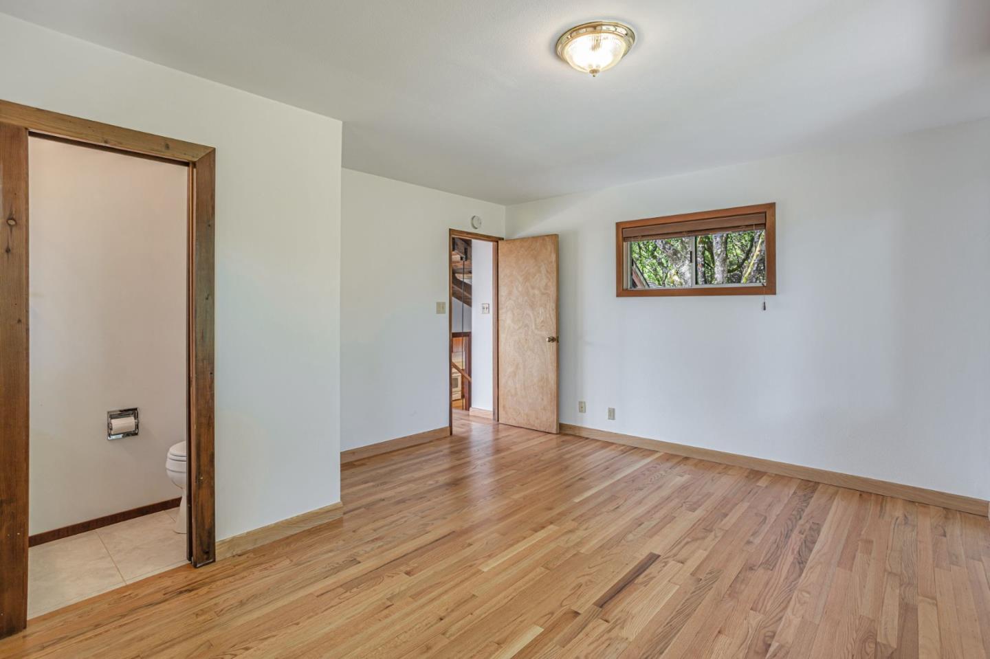 22178 Miller Ridge Road Los Gatos, CA 95033 - Photo 16 of 33 an empty room with wooden floor and windows