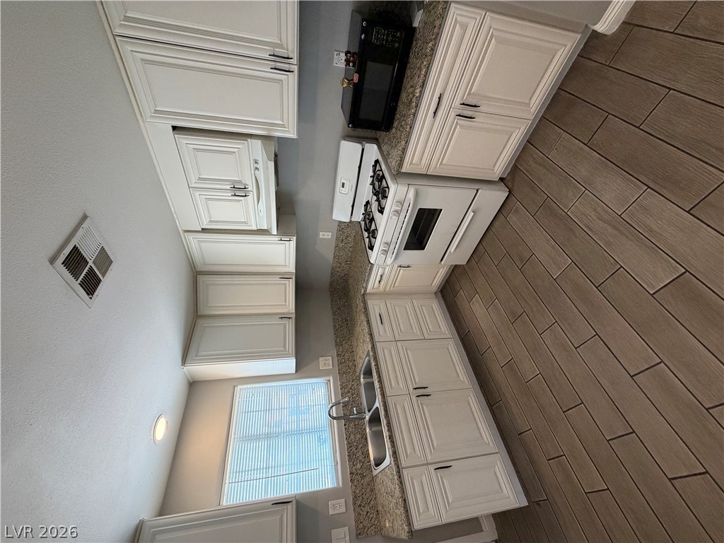 2820 South Sandhill Road, Unit A Las Vegas, NV 89121 - Photo 10 of 26 Functional kitchen with ample cabinet space, a gas range, and a dual-basin sink.