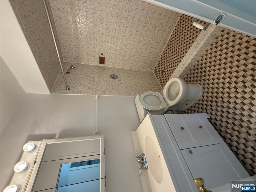 1276 River Road, Unit 2 Edgewater, NJ 07020 - Photo 13 of 16 a bathroom with a sink a toilet a shower and a mirror