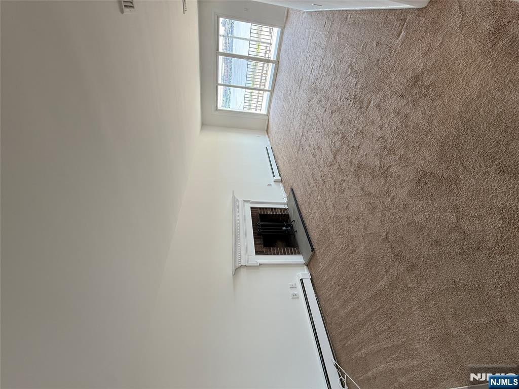 1276 River Road, Unit 2 Edgewater, NJ 07020 - Photo 2 of 16 a view of an empty room with a window and fireplace