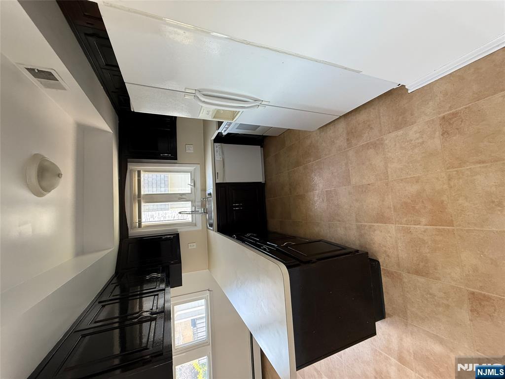 1276 River Road, Unit 2 Edgewater, NJ 07020 - Photo 6 of 16 a room with a bed a window and a television