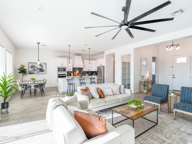 a living room with furniture kitchen view and a window