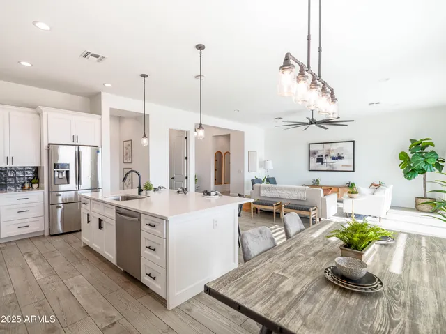 a kitchen with stainless steel appliances kitchen island granite countertop a stove a sink and a refrigerator