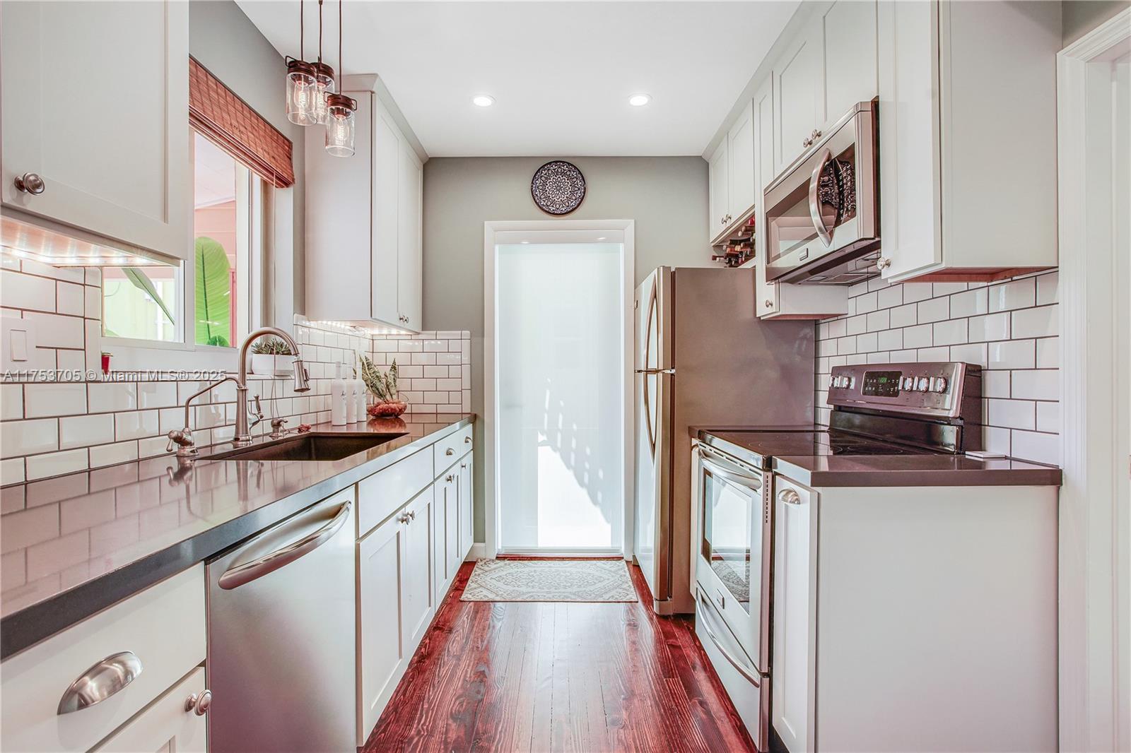 1926 Southwest 17th Terrace Miami, FL 33145 - Photo 11 of 38 a kitchen with stainless steel appliances granite countertop a refrigerator a stove a sink and a microwave