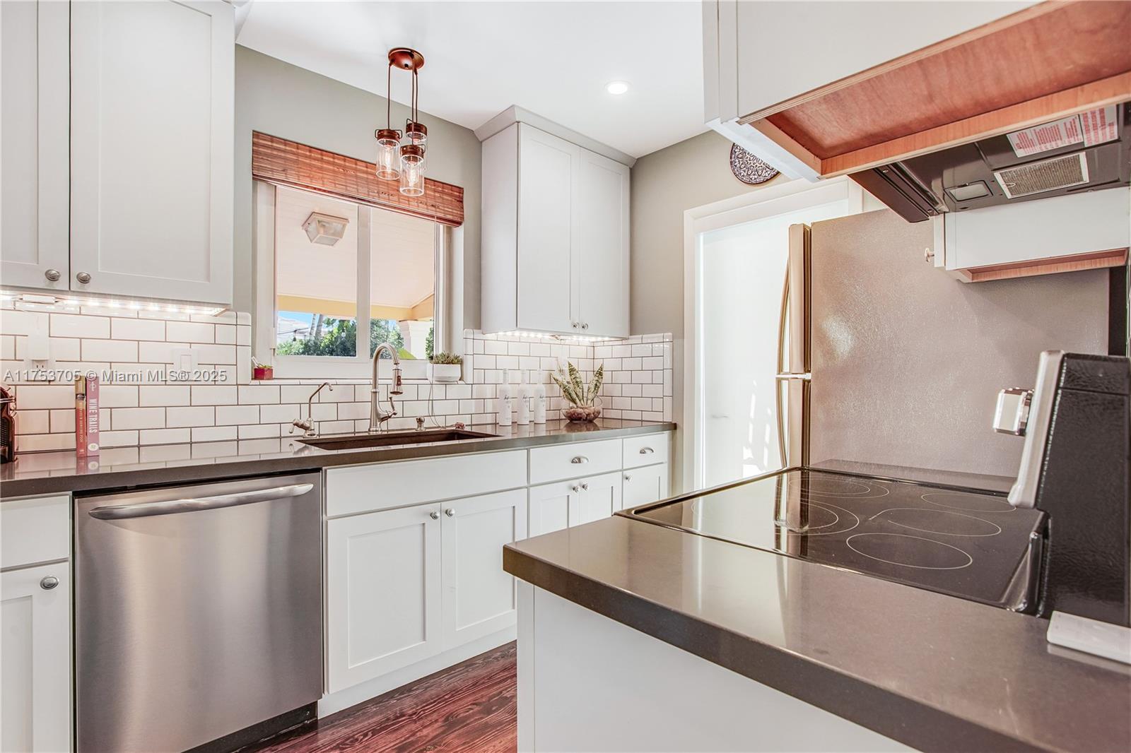 1926 Southwest 17th Terrace Miami, FL 33145 - Photo 12 of 38 a kitchen with stainless steel appliances granite countertop a sink refrigerator and cabinets