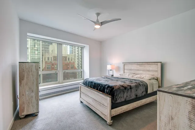 a bed sitting in a spacious bedroom next to a window