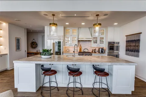 a kitchen with cabinets a sink and chairs