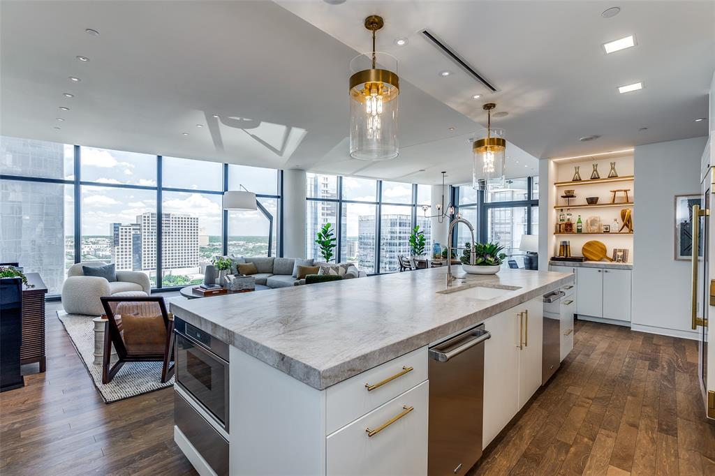 1918 Olive Street, Unit 2002 Dallas, TX 75201 - Photo 5 of 29 a large kitchen with kitchen island a large window a sink and stainless steel appliances