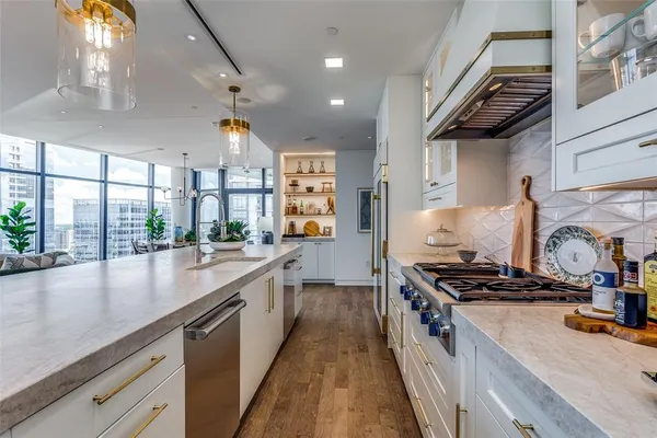 a kitchen with kitchen island a counter space a sink a stove and a window