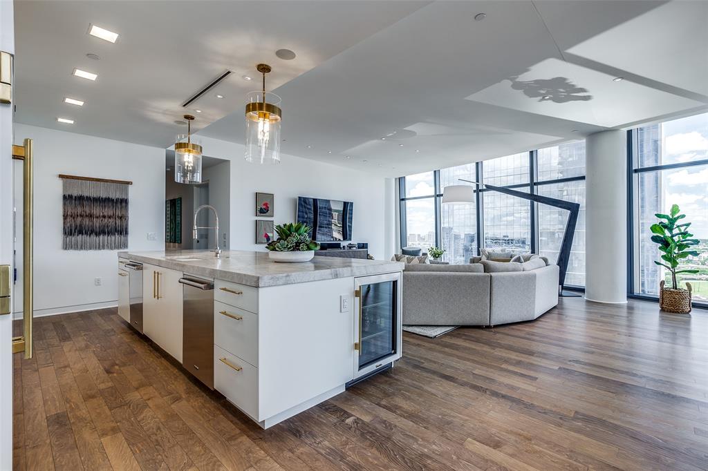 1918 Olive Street, Unit 2002 Dallas, TX 75201 - Photo 7 of 29 a kitchen with stainless steel appliances granite countertop a stove a sink dishwasher a refrigerator and a fireplace with wooden floor