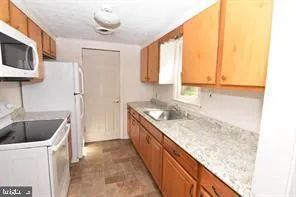 a bathroom with a granite countertop sink and a bathtub