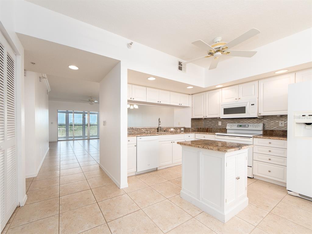 6550 Shoreline Drive, Unit 7502 St. Petersburg, FL 33708 - Photo 3 of 30 a large kitchen with white cabinets and stainless steel appliances
