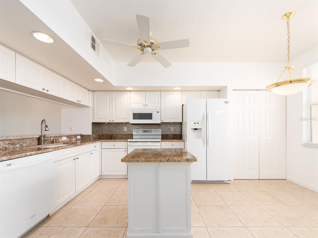 6550 Shoreline Drive, Unit 7502 St. Petersburg, FL 33708 - Photo 4 of 30 a kitchen with stainless steel appliances granite countertop a sink and cabinets